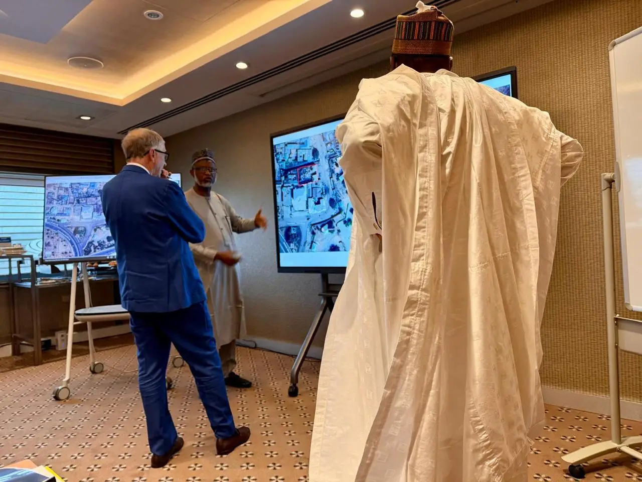 A photograph of the HCM CEO, Dr Ismail Jibrin, Bill Gates, and the Minister of Health Prof. Ali Pate standing together, demonstrating the Gombe State Biometric Attendance Program, a technological initiative aimed at improving attendance tracking and management.